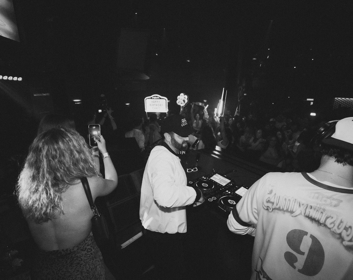 Negus DJing under a round LED light rig